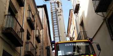 Los bomberos retiran varias tejas que presentaban riesgo de caída en la calle San Pedro de Cuenca