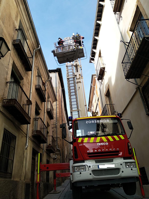Los bomberos retiran varias tejas que presentaban riesgo de caída en la calle San Pedro de Cuenca